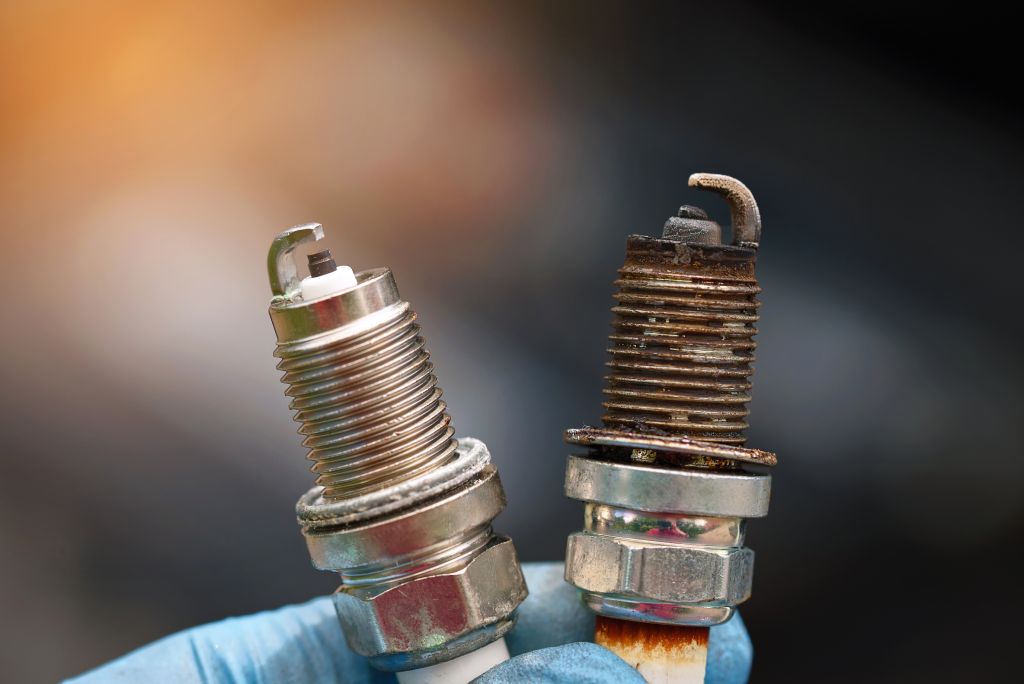 New spark plug next to worn spark plug that’s past due for replacement